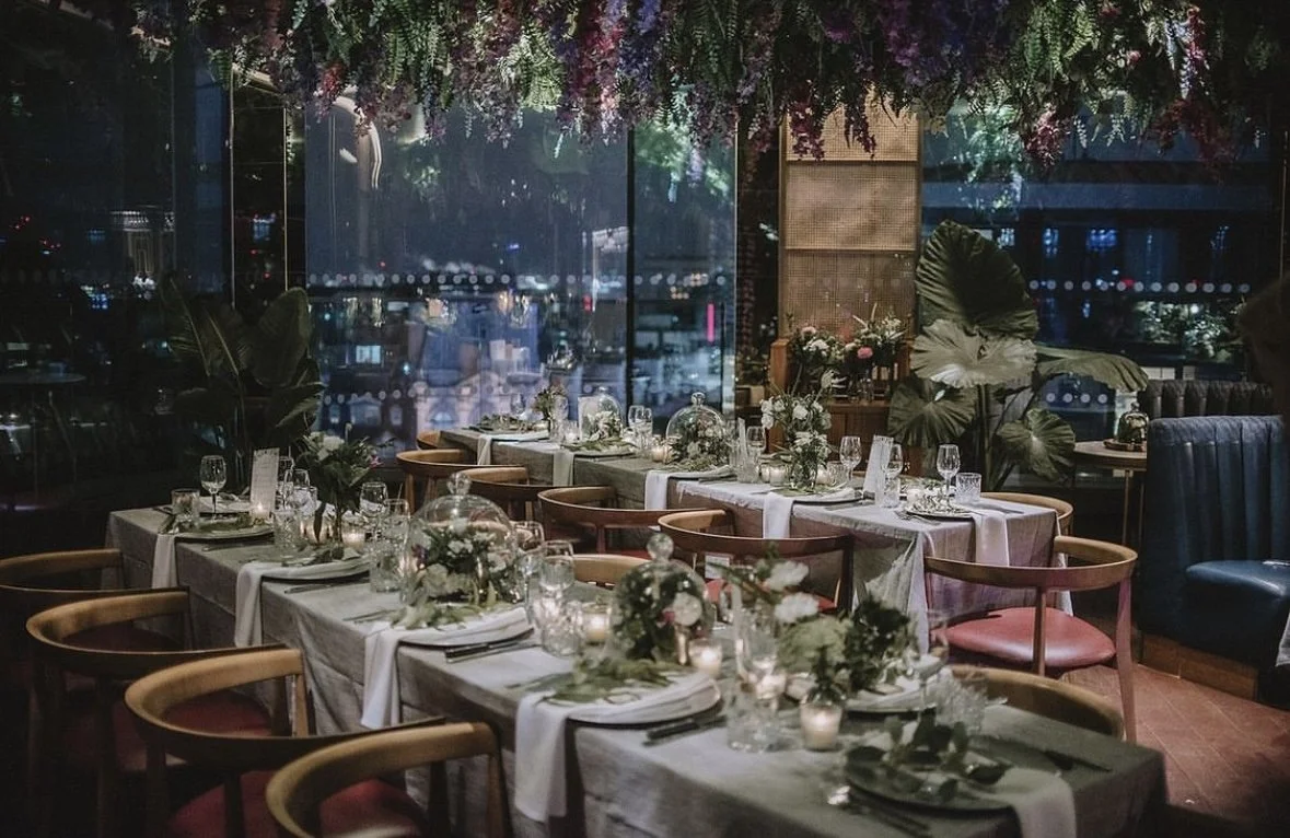 Restaurant gathering styled with seasonal flowers and candlelight
