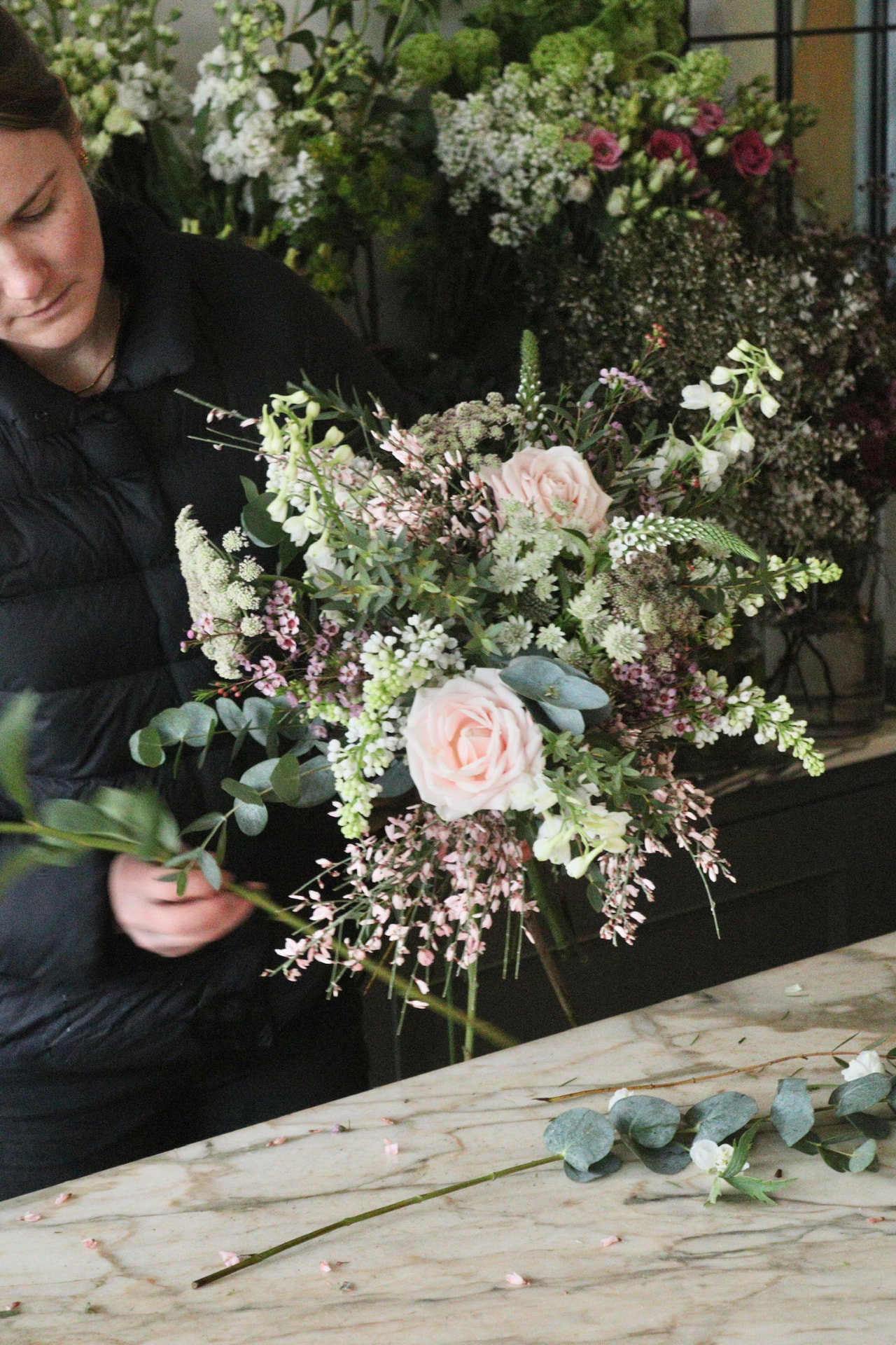 Bramble & Willow florist making a seasonal Friday Flower Box arrangement in the studio